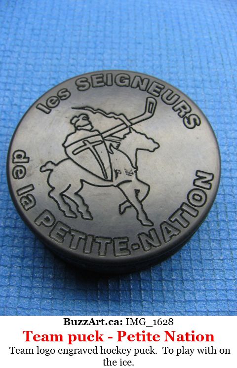 Hockey puck with Petit nation logon on it